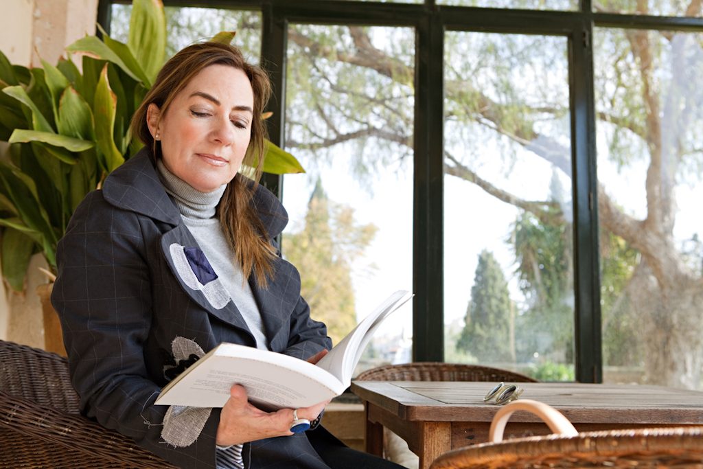 how to keep your conservatory warm showing a woman reading book 