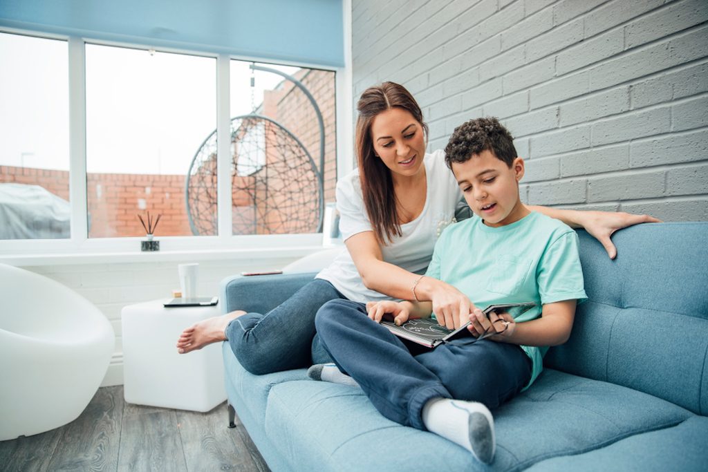 mother and child reading in a conservatory for aluminium conservatory roof panel installation blog post